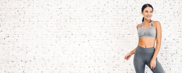 运动女性在运动服放松站锻炼后对复制空间添加文字与白墙背景。饮食的概念。健身和健康的生活方式图片下载