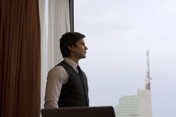 商务人士出差时在酒店房间工作。图片下载