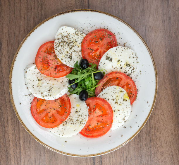 卡布里沙拉配上成熟的番茄和马苏里拉芝士，新鲜的罗勒叶。塞尔维亚食品库存照片图片下载