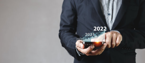 商人触摸智能手机屏幕，显示2022年的增长图表。证券交易分析图表。信息统计图利润全球金融营销。投资和营销理念。图片下载