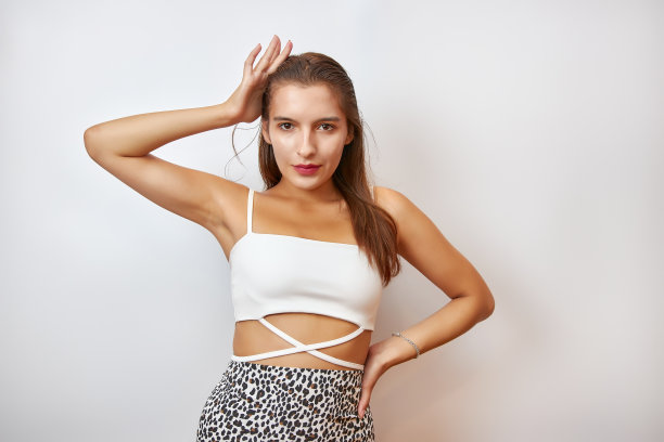 一个漂亮的女孩在白色的背景上为相机摆姿势。图片下载