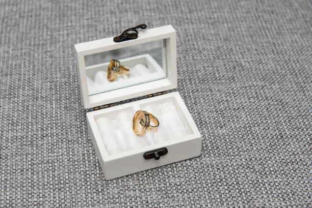 新娘和新郎的结婚戒指放在一个白色的木盒里图片下载