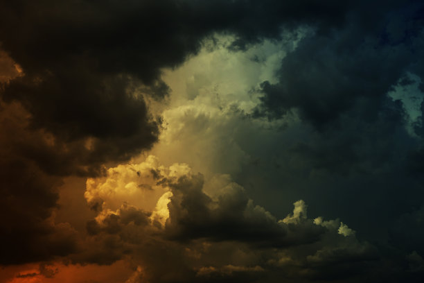 黑色、深绿色、蓝色、蓝绿色、黄色、橙红色的风暴云。戏剧性的夜空背景。风多云雨闪电辉光火。图片下载