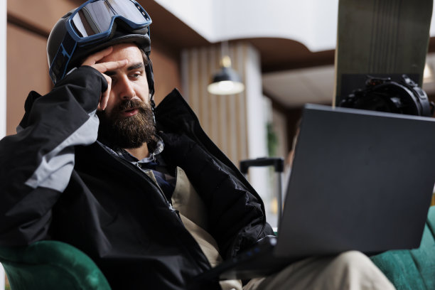 穿着冬衣的男人在用笔记本电脑图片下载