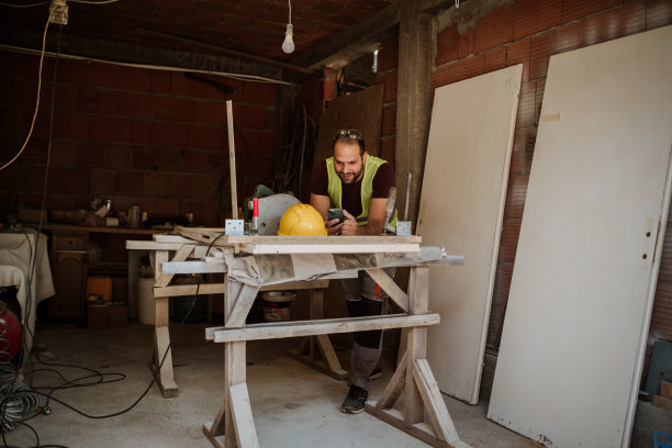 年轻的木匠在做一张木桌图片下载