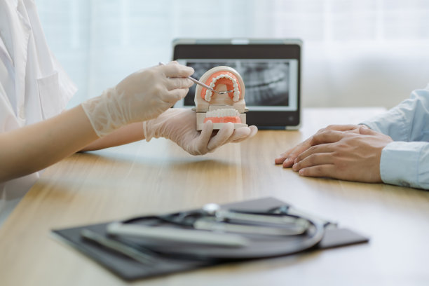 戴橡胶手套的女牙医在诊所检查她的男病人的牙齿健康，使用种植牙指导治疗和x光片显示，口腔保健概念图片下载