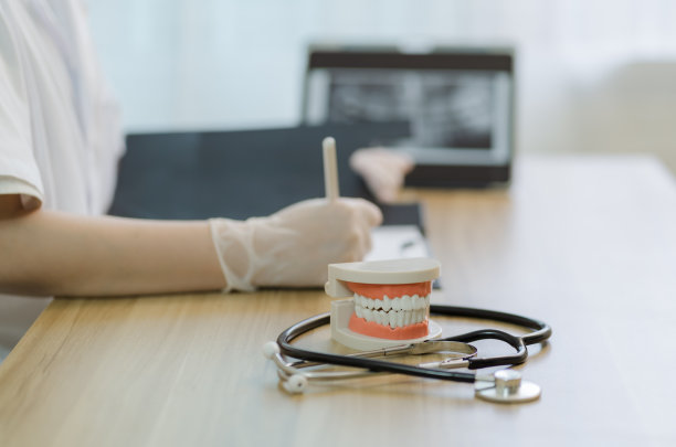女牙医戴橡胶手套在诊所拿病历，用牙科模型指导治疗，x线片成像，口腔保健理念图片下载