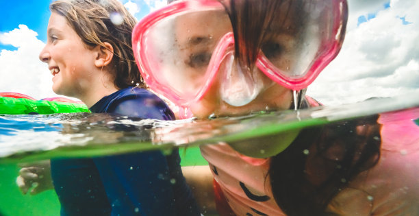顽皮的游泳女孩戴着泳镜在水下游泳图片下载