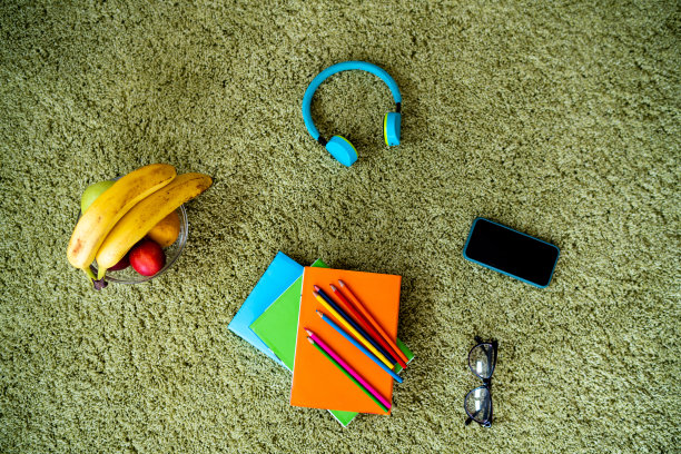 地毯上有学习用品和水果图片下载