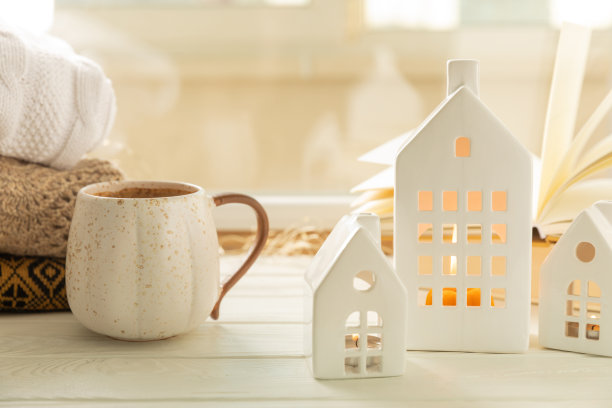 一个圣诞屋的小烛台，里面有燃烧的蜡烛，以书为背景，窗户上挂着冬天的毛衣。概念房地产，度假。圣诞组成。冬季舒适室内图片下载