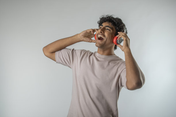 小男孩听着音乐，在白色的背景上跳舞图片下载