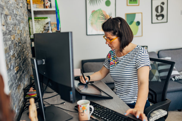 一位专注的女性网页设计师坐在她家庭办公室办公桌前的椅子上，创作设计插图图片下载