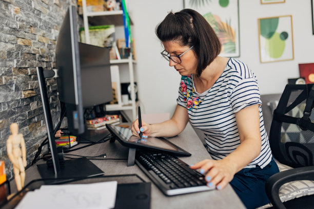 一位女性网页设计师在家里创作好的设计，在绘图板上画画图片下载