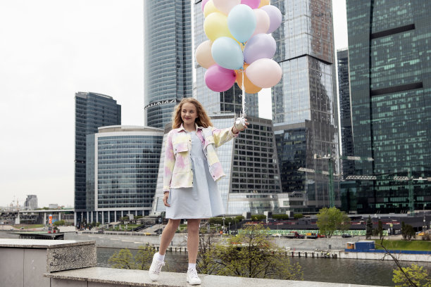 一头金发的女孩手里拿着气球走在城市里。回到学校图片下载