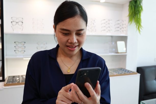 一位女士在眼镜店使用手机图片下载