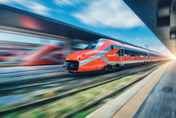 红色高速列车在火车站行驶。快速移动的现代城际列车和模糊的背景。铁路平台。意大利的铁路。商业和客运铁路运输图片下载