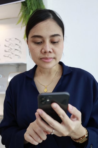 一位女士在眼镜店使用手机图片下载