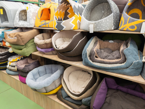宠物店的货架上有卖给猫和狗的床。在宠物店选择狗床。图片下载