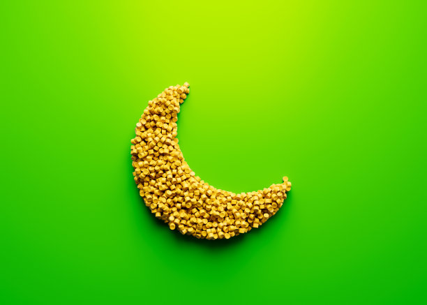 3d独特的新月符号制成的黄色塑料聚合物在明亮的绿色背景3d插图图片下载