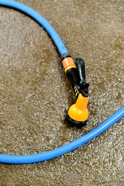 湿地面上的水枪和水管，清洗工具图片下载