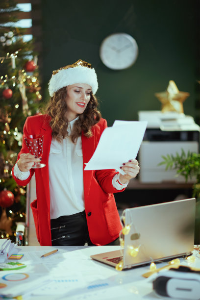 在绿色办公室里挂着圣诞树的微笑的女商人图片下载