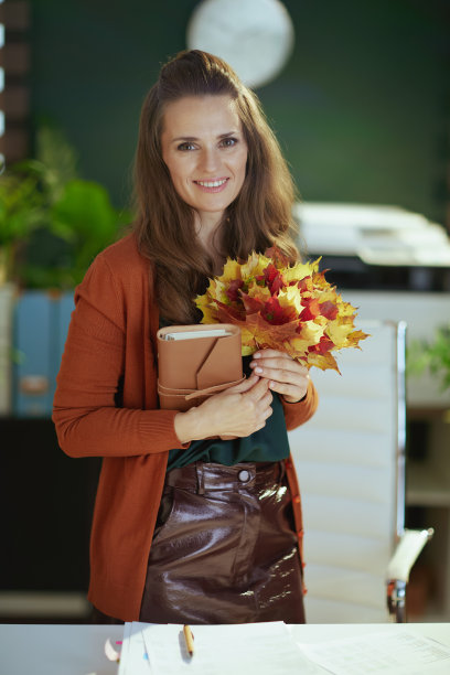 快乐时尚的40岁女企业主在绿色办公室里图片下载