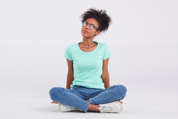 薄荷衬衫、蓝色牛仔裤和时髦的眼镜占据了舞台中央，一名女子摆姿势拍摄了一张迷人的工作室照片。图片下载