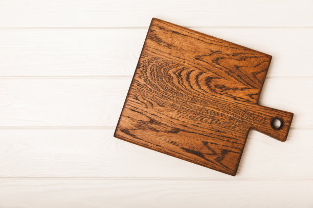 砧板、厨具、洗碗布贴在墙面背景上。现代厨房背景，厨房用具站在木制桌面，空白的文字，正面视图。食谱。模型。图片下载