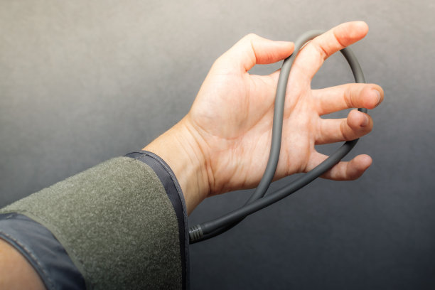 男子手里拿着血压计袖带，手臂紧张。光线照在他的手上。健康不良的概念，高血压和低血压，保健，医学，希望。水平的照片图片下载