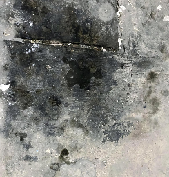 一个肮脏的混凝土地板上有一个洞，在混凝土墙上有一个小洞的螺旋洞的照片。图片下载