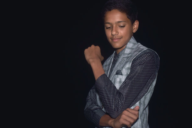 亚洲聪明和英俊的十几岁的男孩黑色衬衫和灰色西装工作室照片拍摄黑色背景图片下载