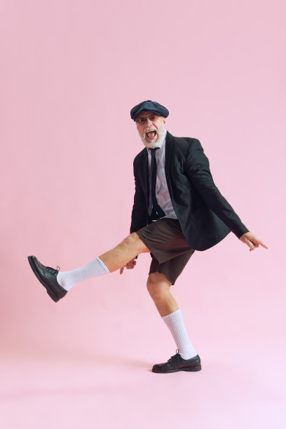 侧面侧面照片的资深大胡子男子穿衬衫黑色短裤漂亮的太阳镜兴奋跳舞的空间孤立在柔和的粉红色背景图片下载