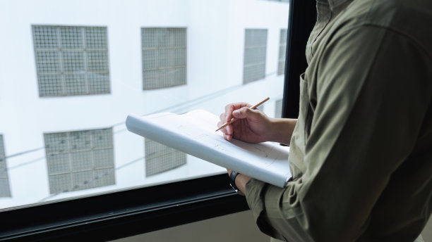 工程师或建筑师在建筑工地拿着铅笔绘制蓝图图片下载