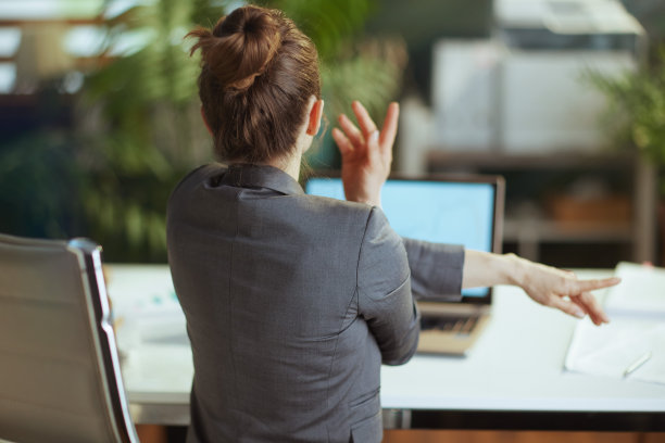 穿着灰色西装的女商人在工作时伸出手图片下载