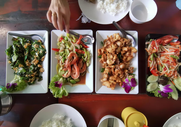 一张桌子上的照片，盘子里放着食物，碗里放着米饭，桌子上的盘子里有一个人在拿叉子。图片下载