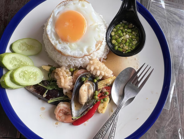 一盘食物的照片，上面有叉子和勺子，盘子里有米饭、虾和蔬菜。图片下载