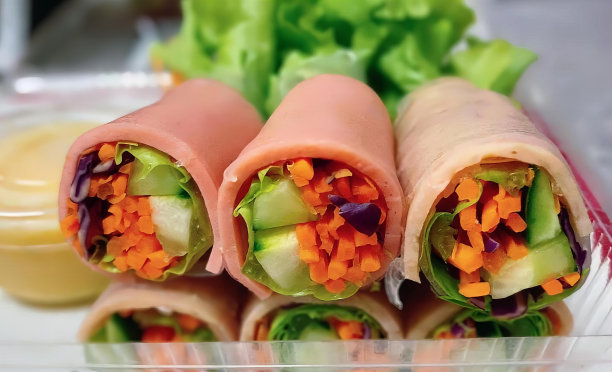 一盘食物的照片，沙拉和包裹，墨西哥卷饼，蔬菜和肉在一个塑料容器。图片下载