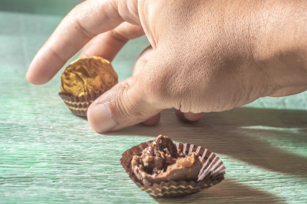 巧克力和金色锚在浅绿色的毛巾上。图片下载