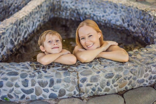 妈妈和儿子在家庭水疗中心放松在圆形室外芳香草药浴，有机护肤，豪华水疗酒店，生活方式的照片图片下载