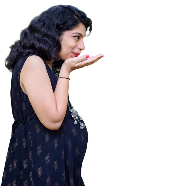 一名怀孕的印度妇女摆姿势拍摄怀孕照片，双手放在腹部，背景是白色的，印度孕妇穿着朴素的孕妇装，把手放在肚子上，拍摄怀孕照片图片下载