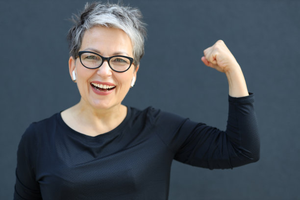 自信成熟的女人用有力的拳头庆祝成功。授权和积极，体现力量和胜利。图片下载