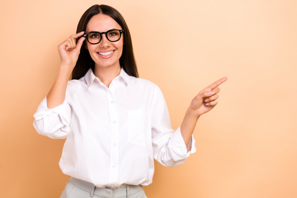 照片上的商务女士穿着白衬衫，手指着空白的空间，触摸眼镜，专家反馈，并孤立在米色背景图片下载