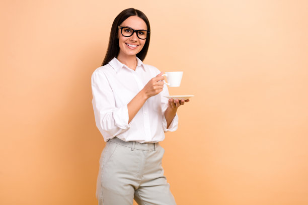 开朗的年轻ceo经理办公室的照片，午餐，咖啡休息，拿杯，喝茶，享受休息的能量孤立在米色的背景图片下载