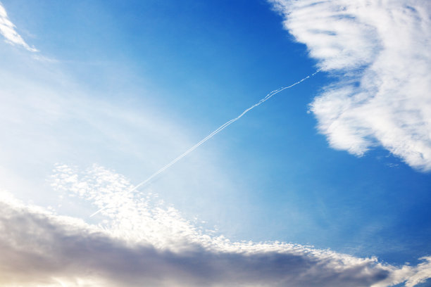 蓝天背景上的飞机凝结轨迹或云线。高质量照片图片下载
