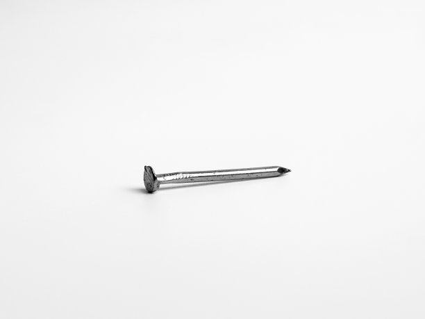 一个银色闪亮尖锐的金属指甲特写照片孤立的白色背景图片下载