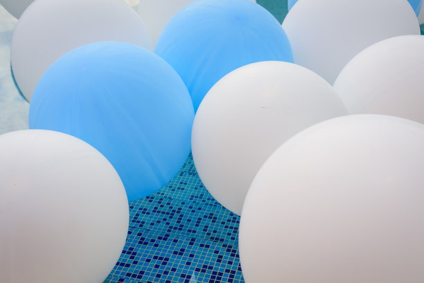 室外蓝色水面上有气球的游泳池。气球在水上。泳池里婚礼的装饰品图片下载