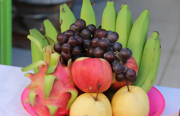 一张桌子上一碗水果的照片，上面有香蕉、火龙果和橙子。图片下载