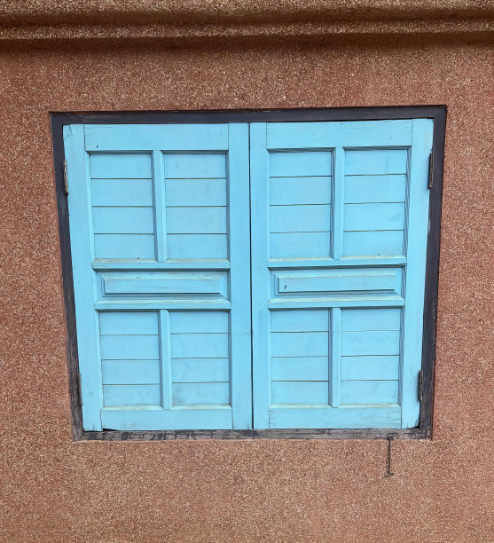 一张蓝色窗户的照片，一只猫坐在窗台上，窗帘是蓝色的，关上了。图片下载