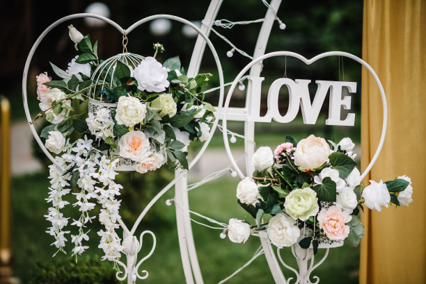 爱装饰。拱门上装饰着白色的花朵和绿色、绿色植物。豪华婚礼的详细地点。后院时髦的装饰。庆祝概念的照片墙。生日宴会招待会。图片下载