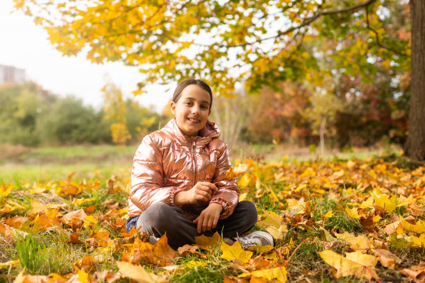 可爱的十几岁的女孩穿着休闲服坐在森林外面。可爱的时髦黑发女郎在秋天的一天图片下载